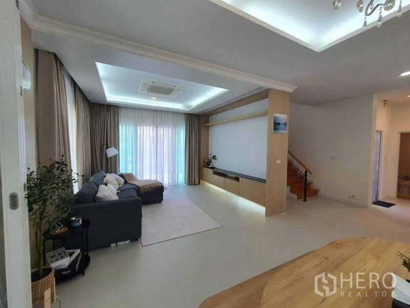 Detached House for rent in Saphan Sung, Bangkok - Spacious lounge with full‑height curtains and floating media cabinet.