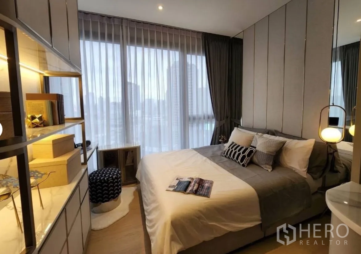Condominium for rent in Din Daeng, Bangkok - Second bedroom with wraparound windows and soft sheer curtains.