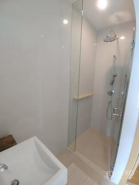 Condominium for rent or sale in Watthana, Bangkok - Contemporary bathroom with glass-enclosed shower and rainfall showerhead.