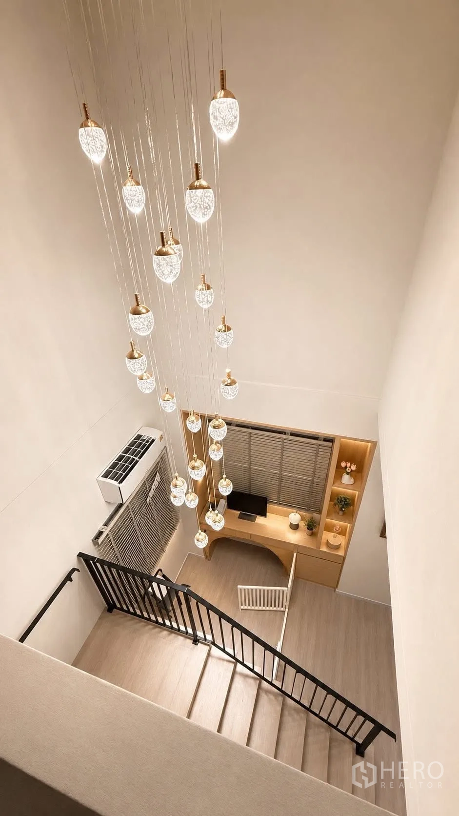 独栋房屋 for rent or sale in Bang Phli, Samut Prakan - 楼梯间多头吊灯，楼下设嵌入式书桌工作区。
