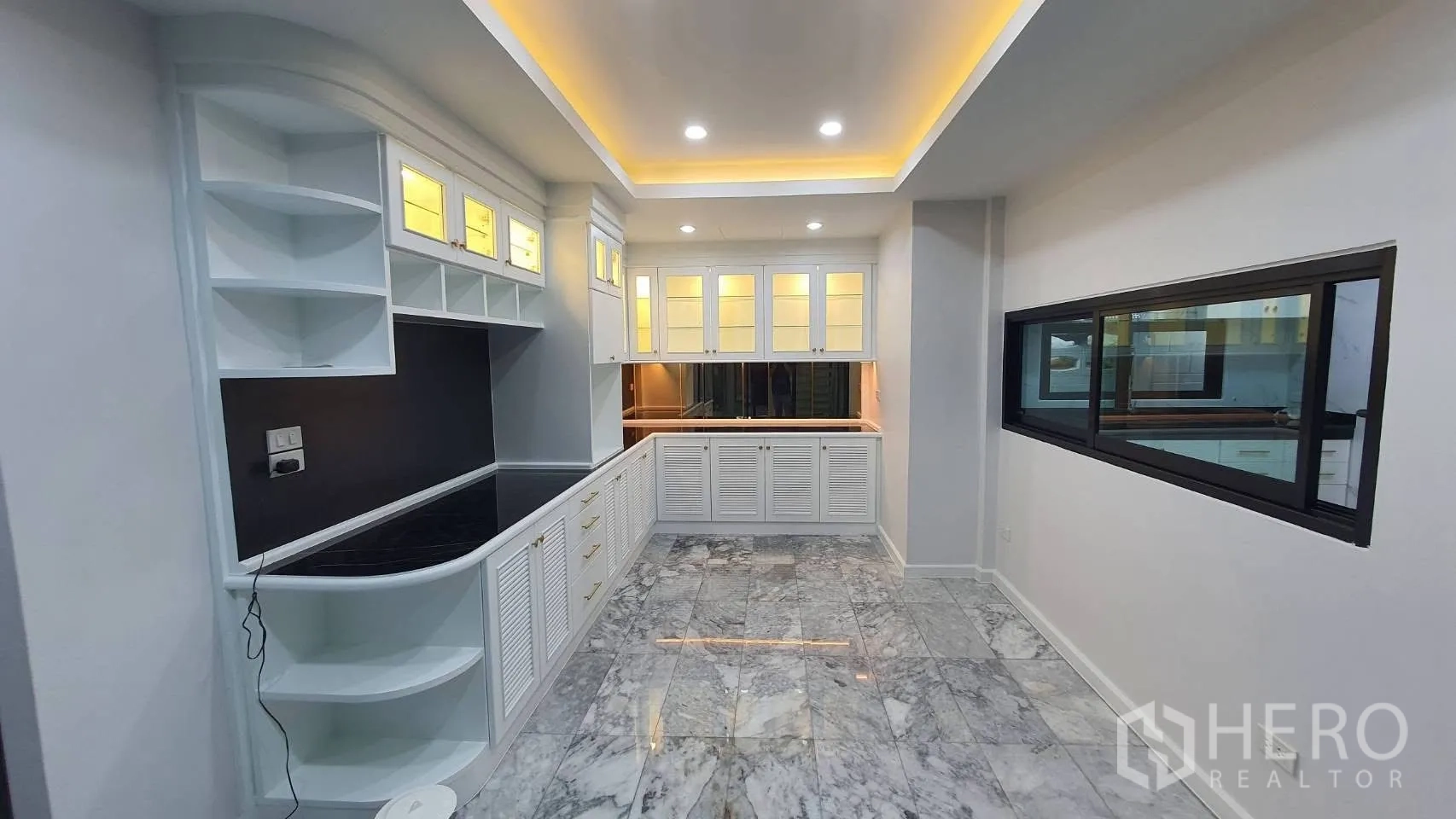Detached House for rent in Lat Phrao, Bangkok - Pantry with white cabinetry, marble floor and warm lighting.