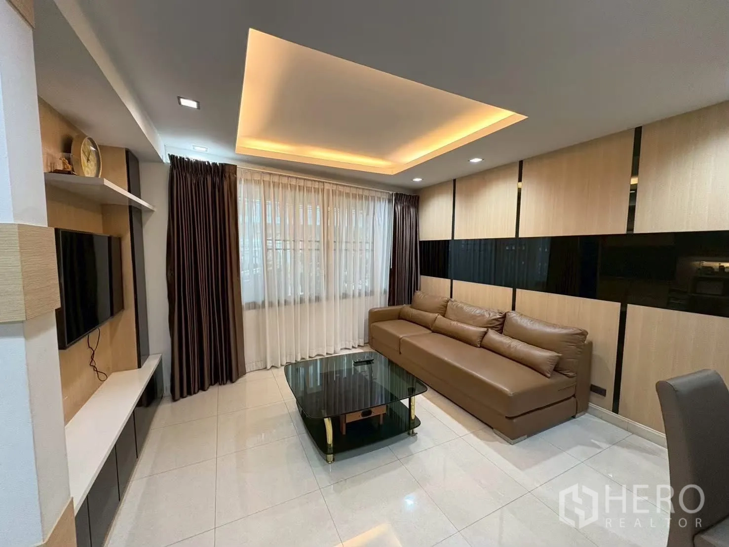 ทาวน์เฮาส์ for rent in Pathum Wan, Bangkok - พื้นที่นั่งเล่นมีชั้นวางทีวี หน้าต่างบานใหญ่ และโซฟาทรงยาว.