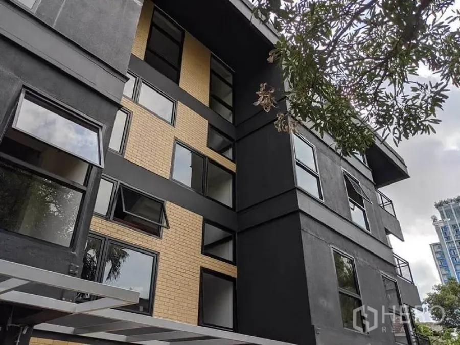 办公空间 出租在Phaya Thai, Bangkok - 低层现代建筑外观，黑色与黄色砖立面，配可开启窗