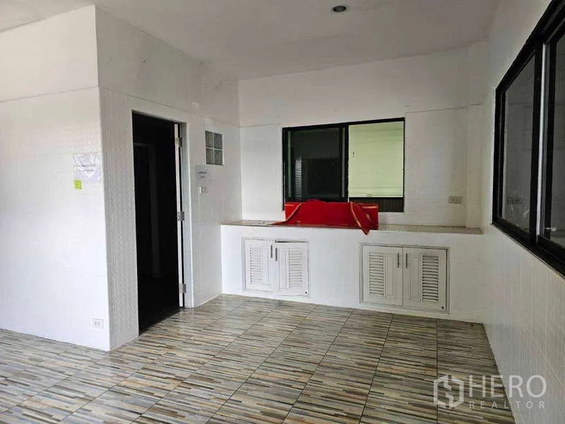 Warehouse for rent or sale in Khlong Toei, Bangkok - Office pantry area with large windows and base cabinets inside the warehouse office.