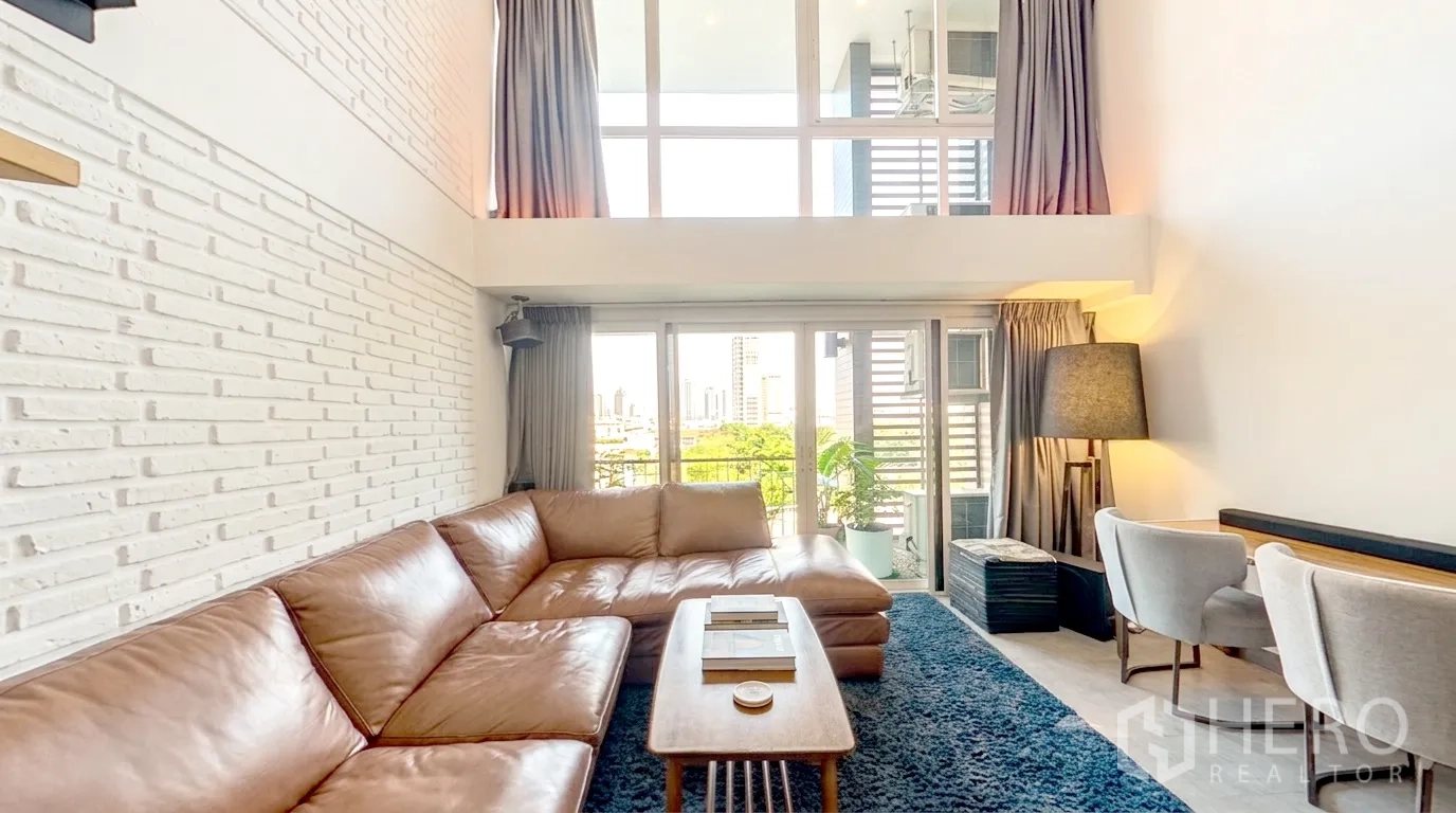 คอนโด for rent in Watthana, Bangkok - ห้องนั่งเล่นเพดานสูงสองชั้น หน้าต่างสูงเต็มผนัง และโซฟาตัวใหญ่