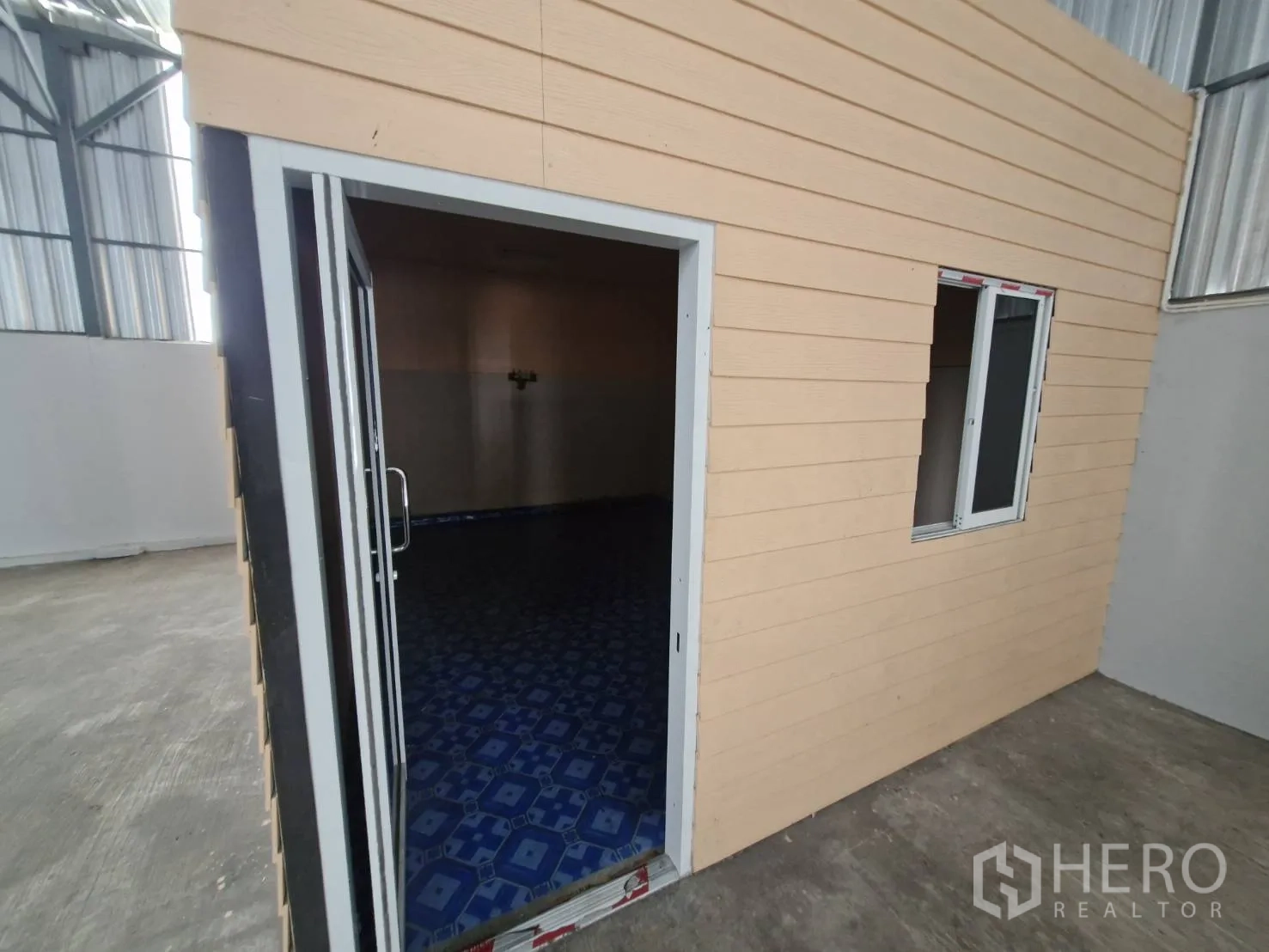 Warehouse for rent in Nakhon Pathom - Close-up of the built-in office cabin inside the warehouse with window and sliding door.