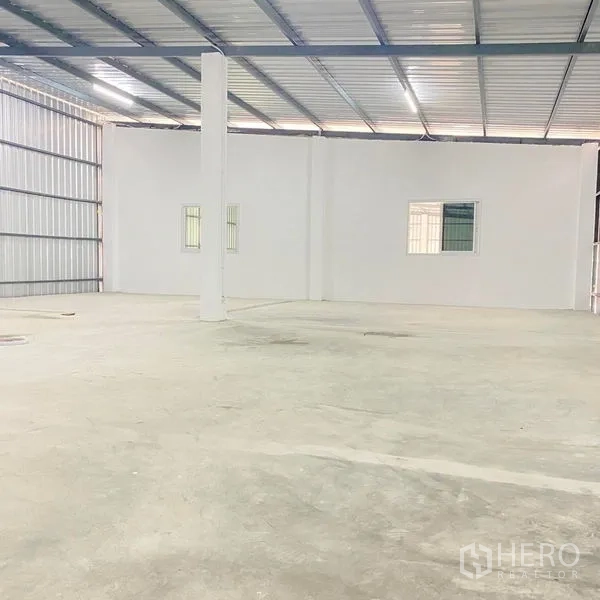 Warehouse for rent in Bang Khae, Bangkok - Open storage bay with white partition wall and windows suitable for office or meeting room build-out.