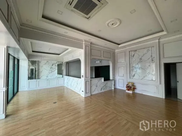Office Space for rent in Prawet, Bangkok - Elegant open office with coffered ceilings, marble wall panels and light wood flooring.