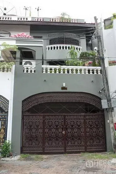 联排别墅 出租在Khlong Toei, Bangkok - 三层联排别墅外立面，雕花金属大门与拱形入口及阳台绿植。