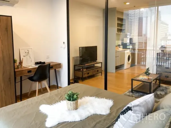 公寓 出租或出售在Bang Rak, Bangkok - 从卧室望向客厅与小厨房，推拉玻璃门，配电视与书桌。