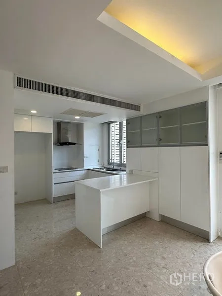 Townhouse for sale in Yan Nawa, Bangkok - Modern white kitchen with island-style counter and ample storage cabinetry