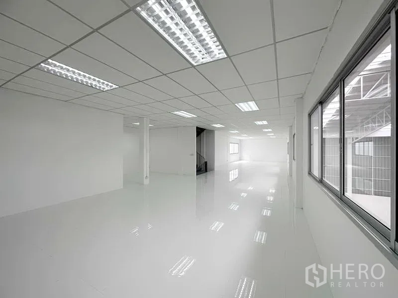 工厂 出租在Pathum Thani - 现代办公室楼层，白色地砖与楼梯入口。