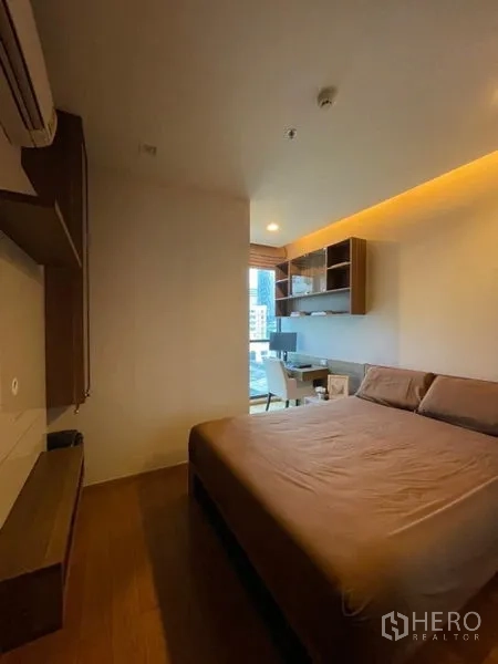 公寓 出售在Bang Rak, Bangkok - 舒适次卧，配床与嵌入式书桌，窗外城市景观。