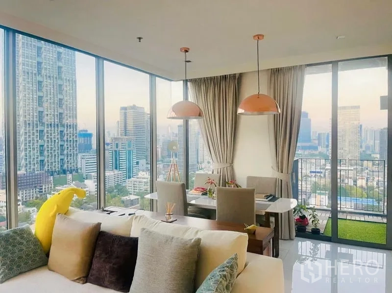 Condominium for rent or sale in Sathon, Bangkok - Dining area next to balcony doors with copper lamps and city views.