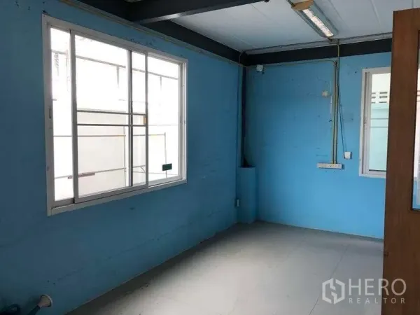 Warehouse for rent in Pak Kret, Nonthaburi - Compact blue-painted office room with window, ceiling light and visible power points.