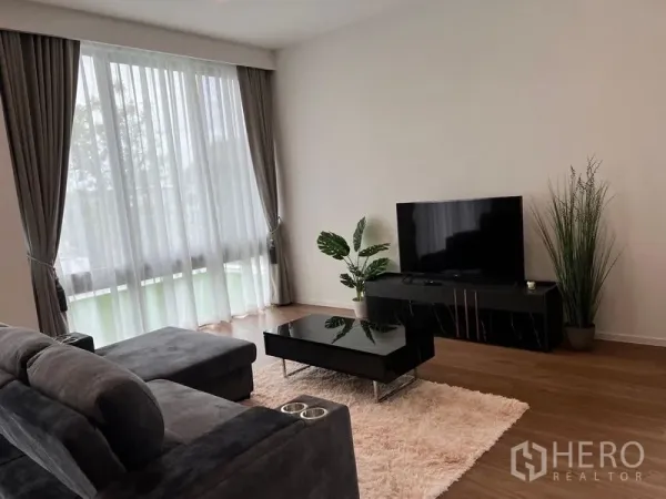 Detached House for rent - Bright lounge with large curtains, TV cabinet and indoor plants on wood flooring.