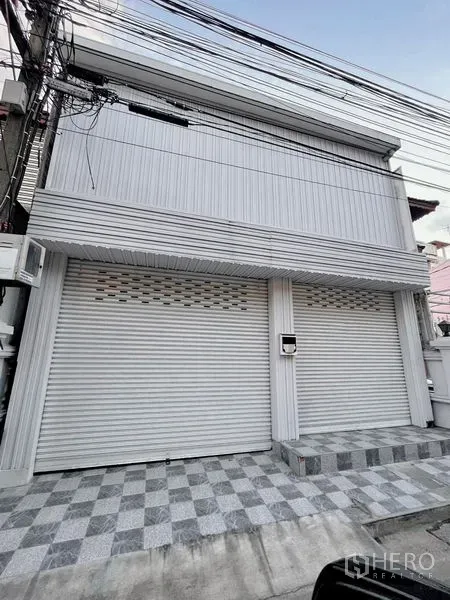 Townhouse for rent in Huai Khwang, Bangkok - Two-storey townhouse exterior with roller shutters and tiled front patio.