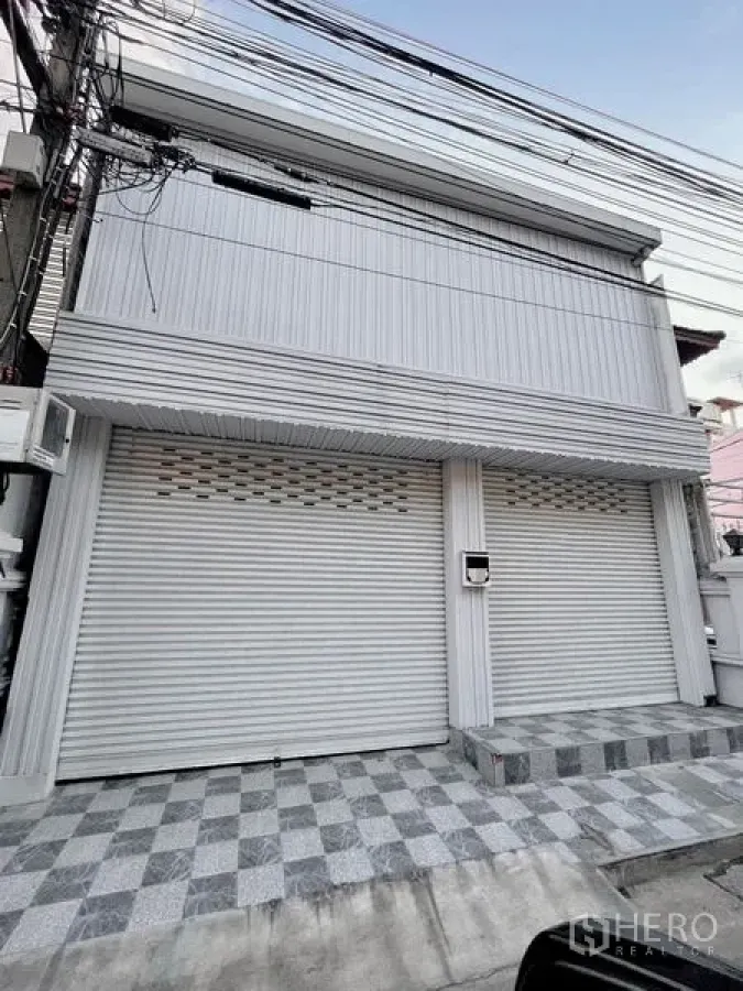 Townhouse for rent in Huai Khwang, Bangkok - Two-storey townhouse exterior with roller shutters and tiled front patio.
