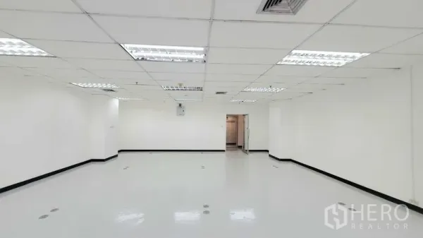 办公空间 出租在Watthana, Bangkok - 宽敞空置办公室，白墙、天花灯、地面线槽端口与玻璃入户门。