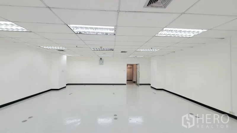 办公空间 出租在Watthana, Bangkok - 宽敞空置办公室，白墙、天花灯、地面线槽端口与玻璃入户门。