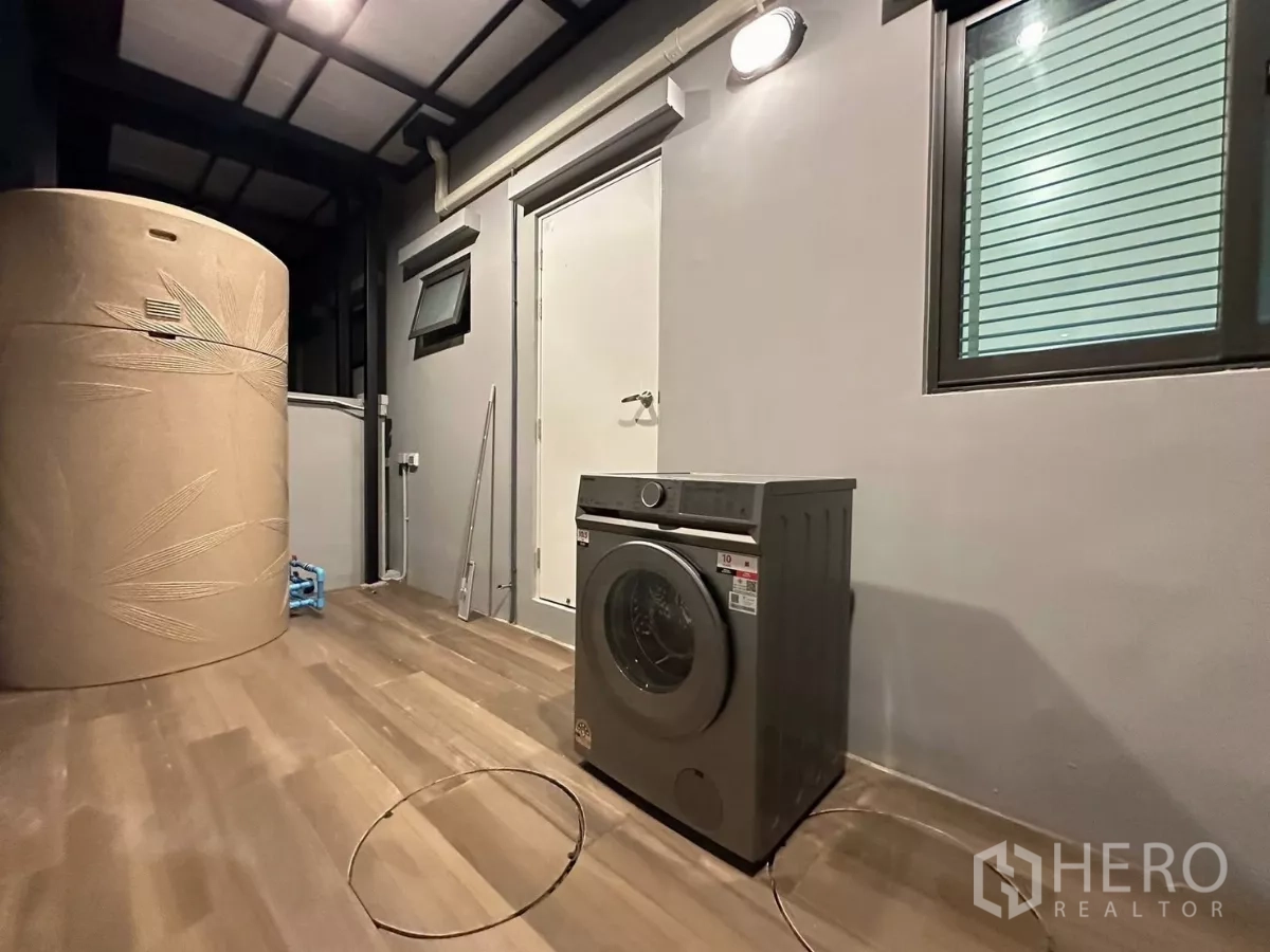 Townhouse for rent in Bang Phli, Samut Prakan - Covered rear utility area with washing machine and water tank.