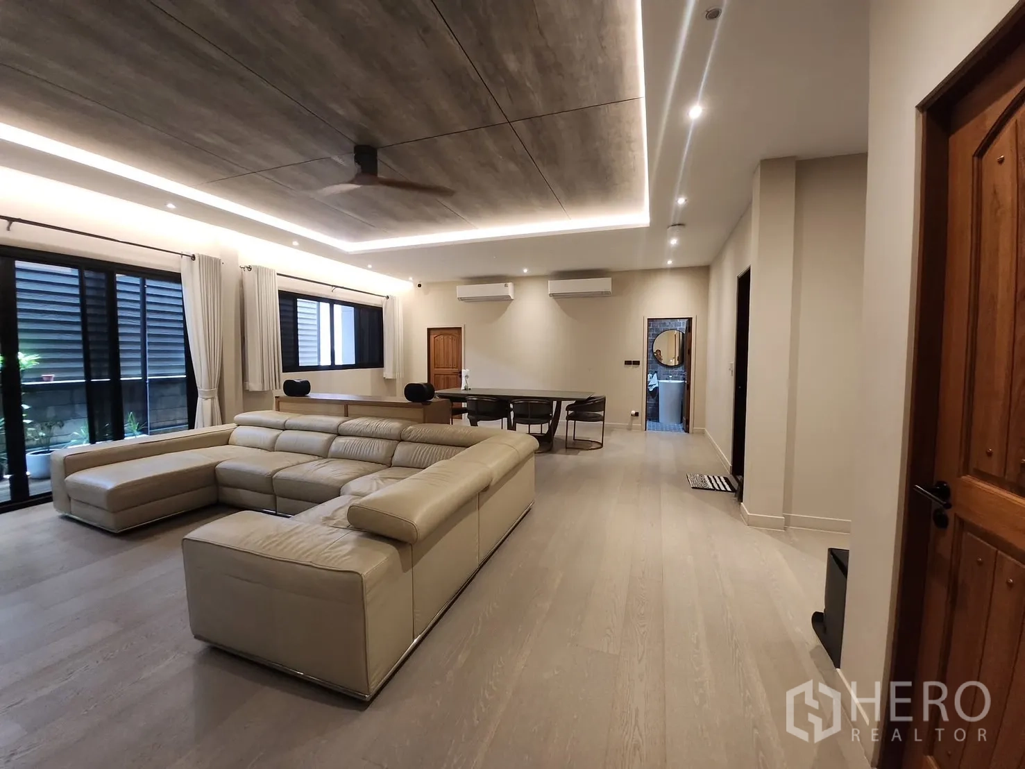 บ้าน ให้เช่าในBang Phli, Samut Prakan - ห้องนั่งเล่นกว้าง โซฟาหนังตัวแอล ไฟฝ้าซ่อนไฟ และพื้นลายไม้