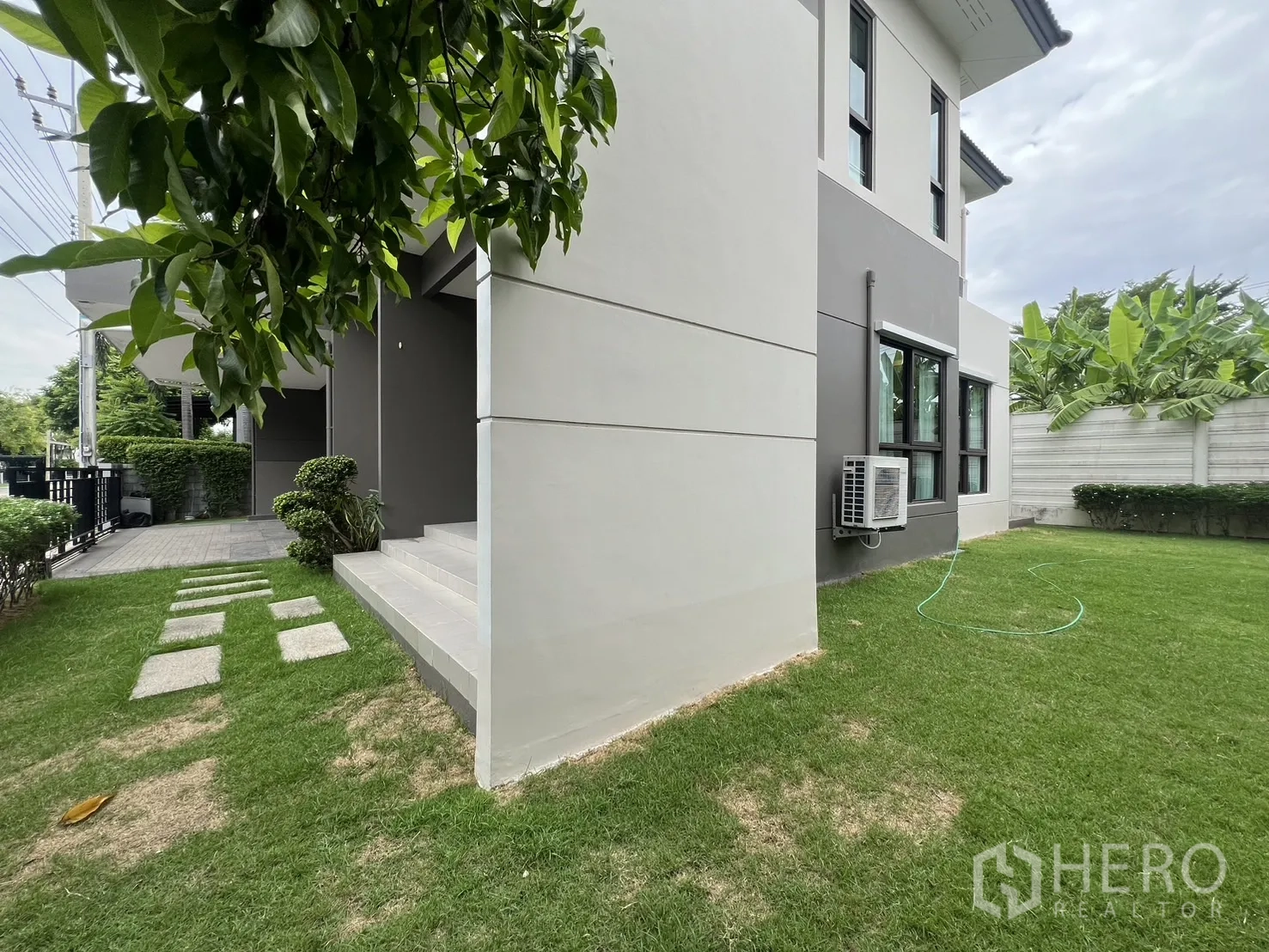 Detached House for rent or sale in Prawet, Bangkok - Corner of the house with lawn and front steps.