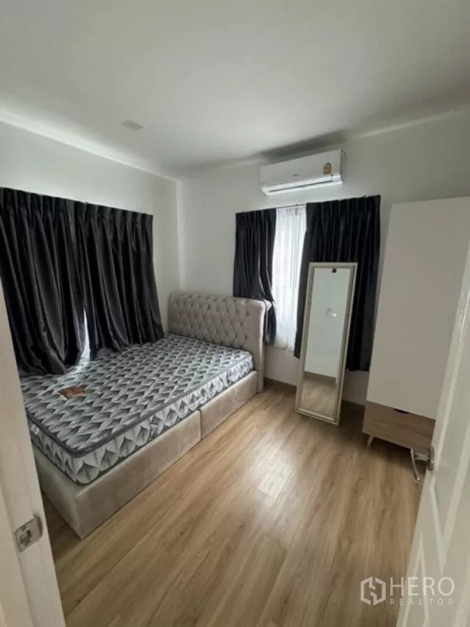Detached House for rent in Thanyaburi, Pathum Thani - Cozy secondary bedroom with bed, air conditioner and blackout curtains.