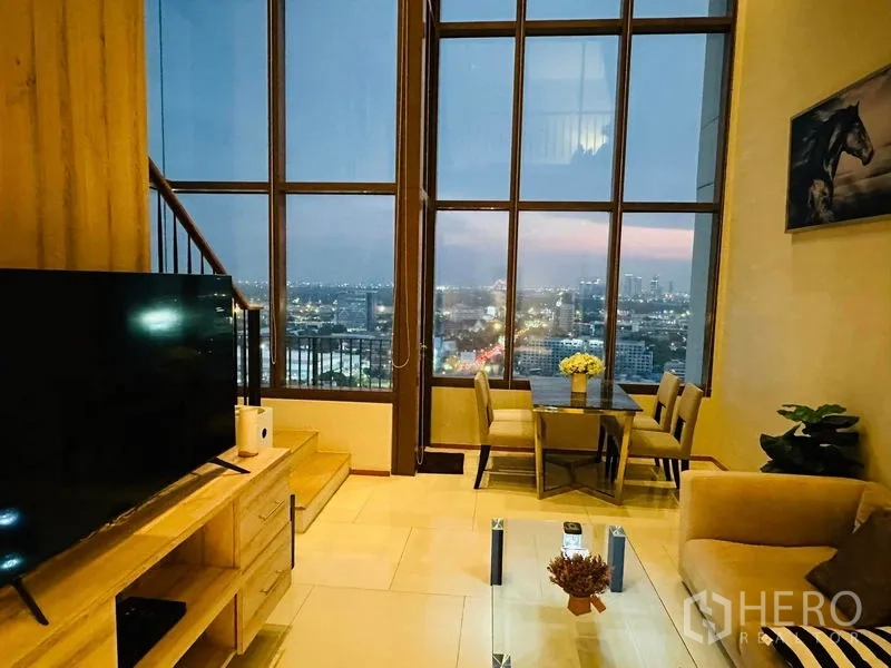 公寓 出租在Bangkok - 客餐厅一体，巨幅玻璃墙展现黄昏天际线