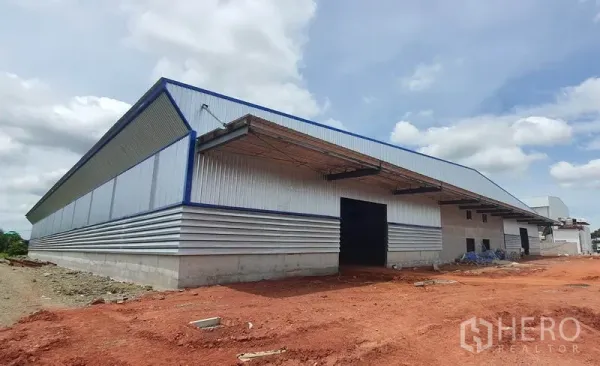 Warehouse for rent in Mueang Samut Sakhon, Samut Sakhon - Newly built metal-clad warehouse exterior with loading canopy and wide yard in Mueang Samut Sakhon.