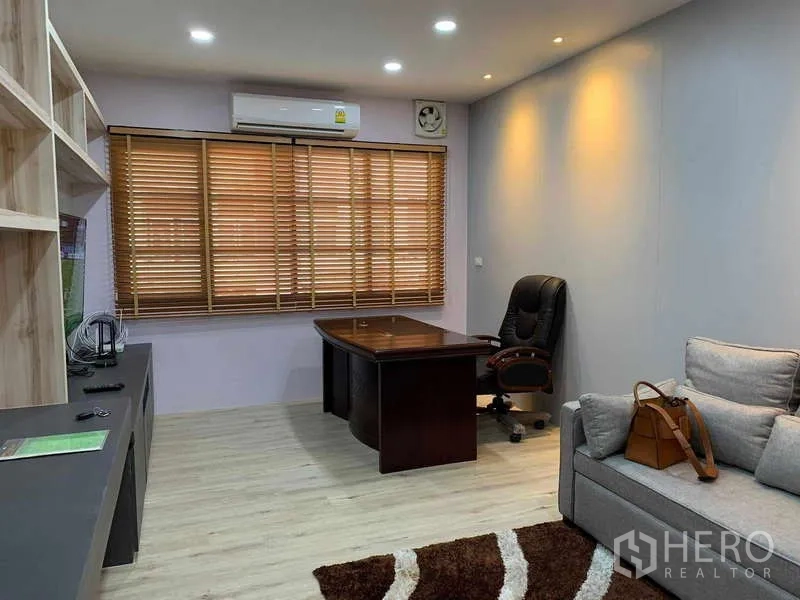 Townhouse for rent - Air-conditioned home office/living room with wooden blinds, built-in shelving and executive desk in a Din Daeng townhouse.