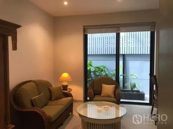 联排别墅 出租在Khlong Toei, Bangkok - 温馨的休闲角，藤编沙发组与临窗花槽。