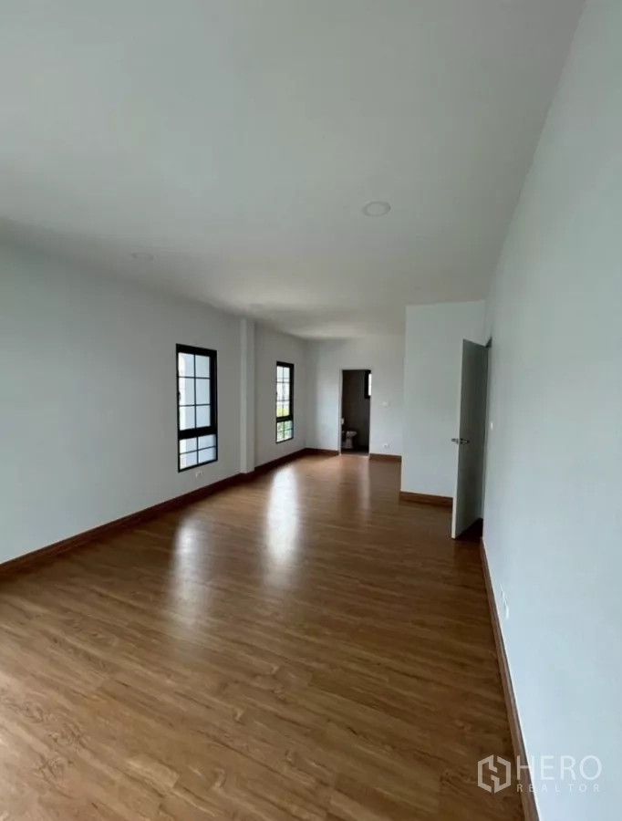 Detached House for rent in Bang Phli, Samut Prakan - Alternate view of the long upstairs room with windows and interior doorway.