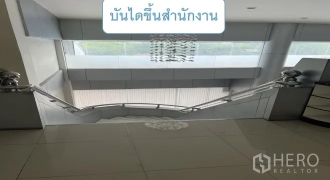 货栈 出租在Mueang Pathum Thani, Pathum Thani - 不锈钢扶手楼梯通往办公楼层，顶有吊灯