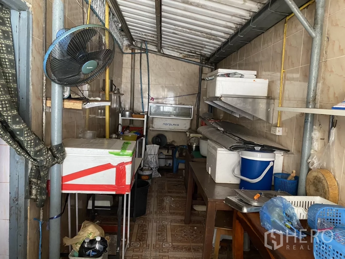 Shophouse for rent in Khlong Toei, Bangkok - Narrow prep kitchen with tiled walls, shelves and ventilation fan.
