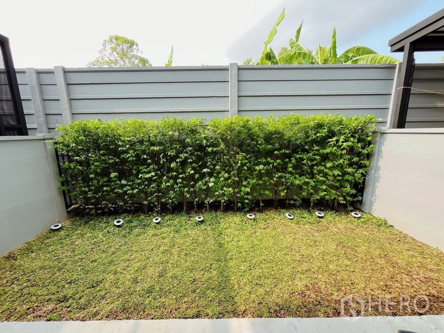 ทาวน์เฮาส์ for rent in Bang Phli, Samut Prakan - มุมมองตรงของสวนส่วนตัวพร้อมพุ่มไม้ตัดแต่งและไฟฝังพื้น.