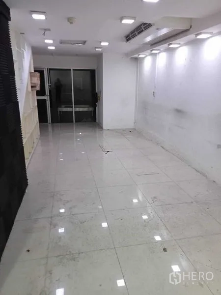 Retail Space for rent in Watthana, Bangkok - Lower-level retail area featuring white floor tiles, recessed lighting and rear glass doors.