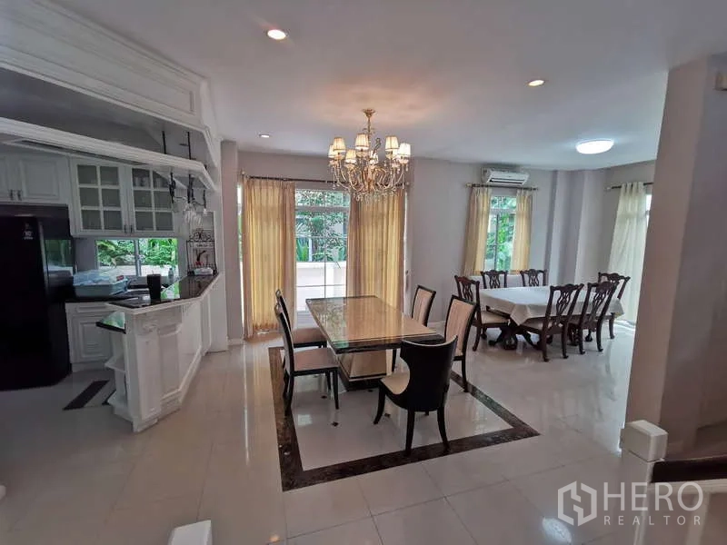 Detached House for rent - Spacious dining room with a chandelier, marble-top table, and a second dining set opening to the pantry kitchen and terrace.