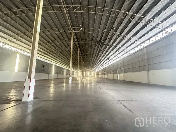 Warehouse for rent in Bang Pa-in, Phra Nakhon Si Ayutthaya - Deep interior perspective of open warehouse floor and skylit steel roof structure.