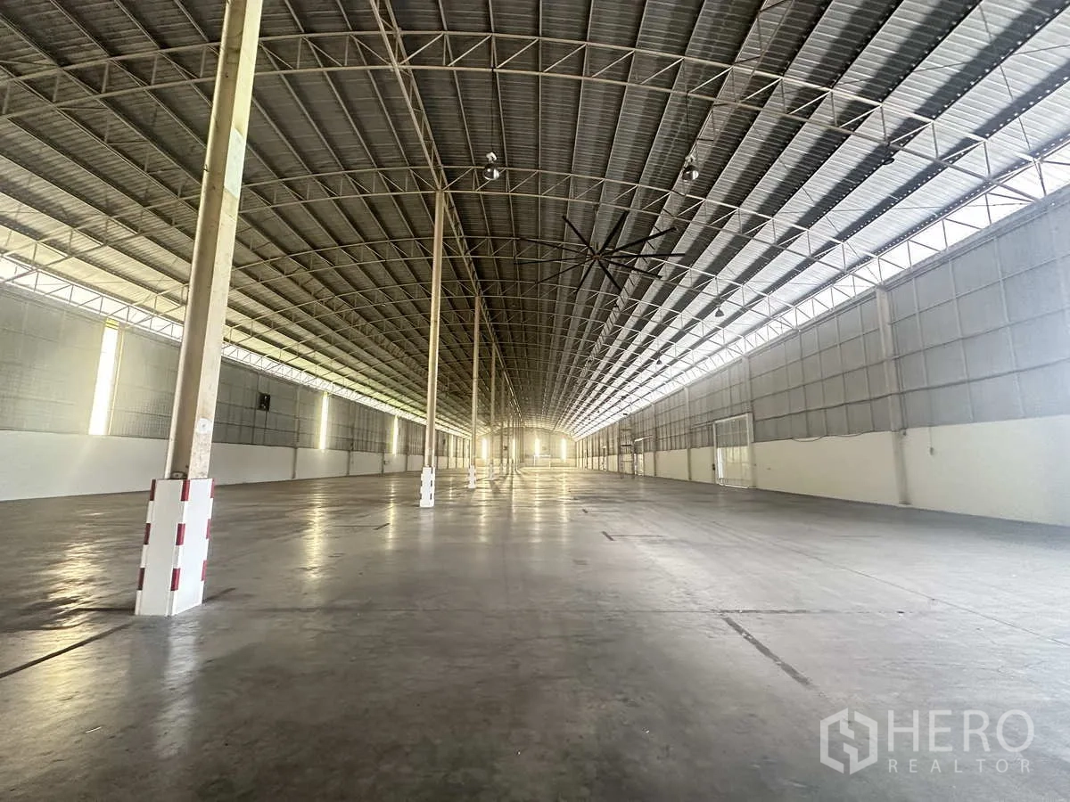 Warehouse for rent in Bang Pa-in, Phra Nakhon Si Ayutthaya - Deep interior perspective of open warehouse floor and skylit steel roof structure.