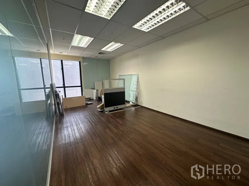 Office Space for rent in Bang Rak, Bangkok - Empty office room with glass wall, wood floor and stored partitions.