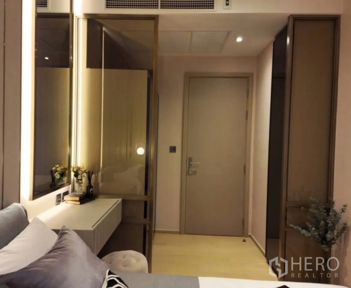 Condominium for rent in Din Daeng, Bangkok - Bedroom corner with dressing console, mirror lighting, and door.