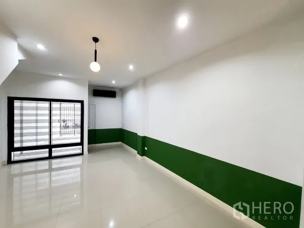 带办公室的家 出租在Khlong Toei, Bangkok - 一层明亮开放空间，亮面地砖，绿色装饰墙与带防盗格栅的推拉门。