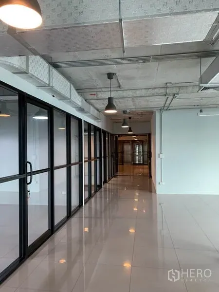 办公空间 出租在Phaya Thai, Bangkok - 走廊宽敞，工业风吊灯与整排推拉玻璃门相伴。