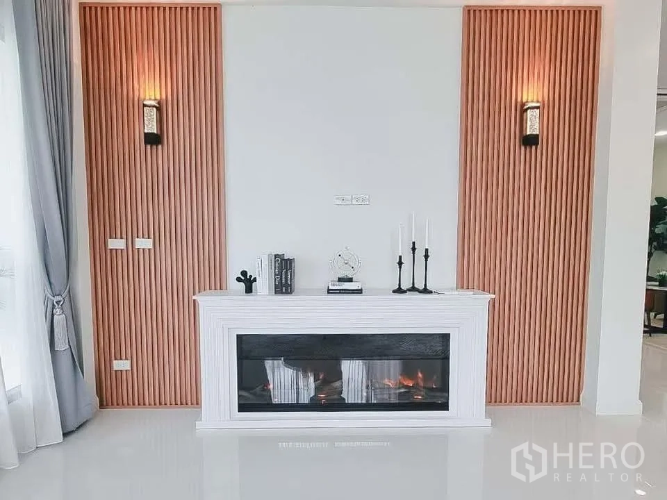 独栋房屋 for rent or sale in Bang Phli, Samut Prakan - 白色装饰电壁炉置于竖向木饰面背景墙中央。