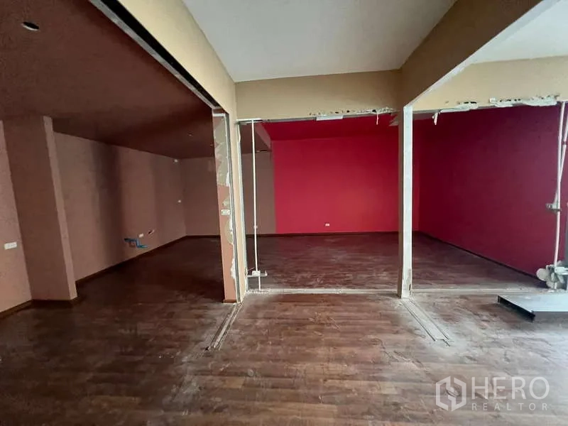 Retail Space for rent in Phaya Thai, Bangkok - Partitioned rooms with dark wood flooring and a red accent wall for flexible layout options.