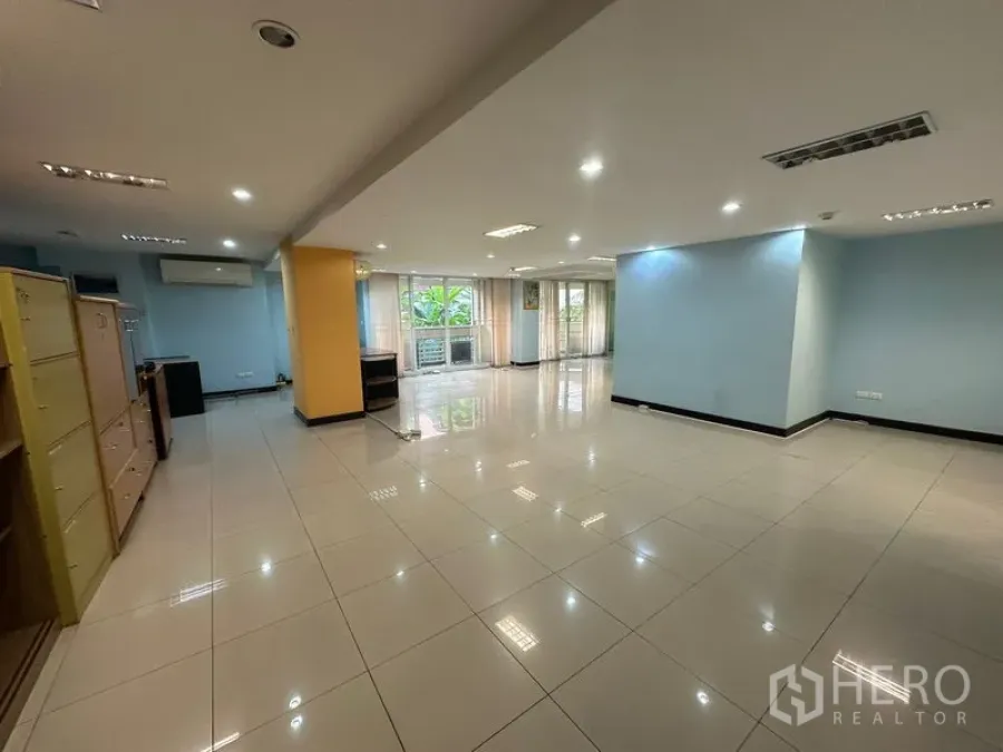 Office Space for sale - Bright open workspace with tiled flooring and garden-view windows.
