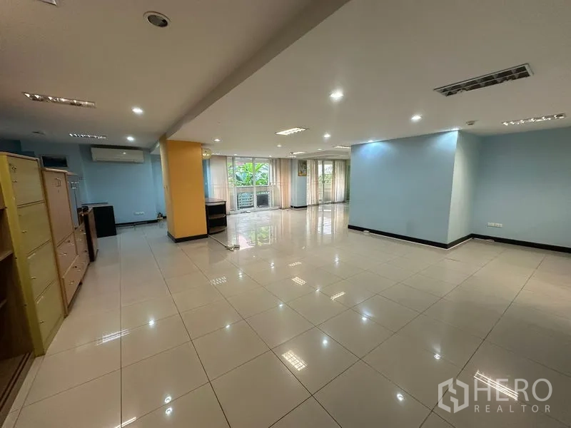 Office Space for sale - Bright open workspace with tiled flooring and garden-view windows.