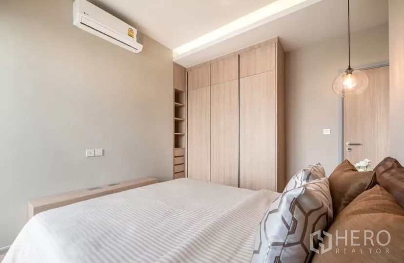 Condominium for rent in Chatuchak, Bangkok - Master bedroom opposite angle with full-height wardrobes and soft ceiling lighting.