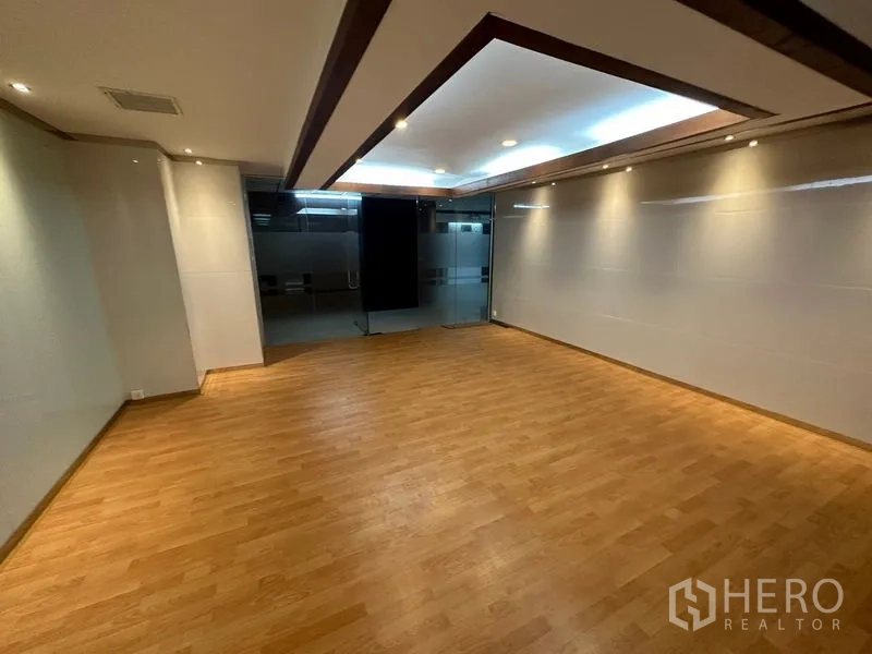 办公空间 出租在Watthana, Bangkok - 接待或会议室，木地板与天花灯，旁为磨砂玻璃墙。